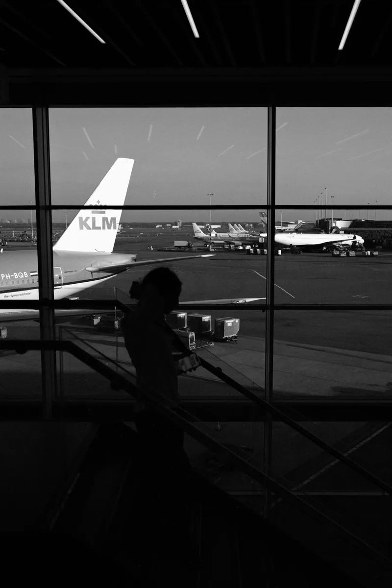 Traveler looking out an airport window at airplanes