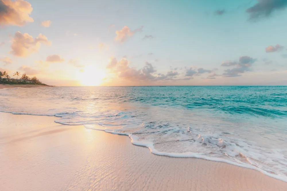 Quiet tropical coastline with pale sand and clear blue water