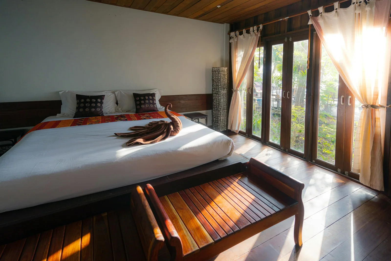 Warm, elegant Thai-style hotel room with a comfortable bed
