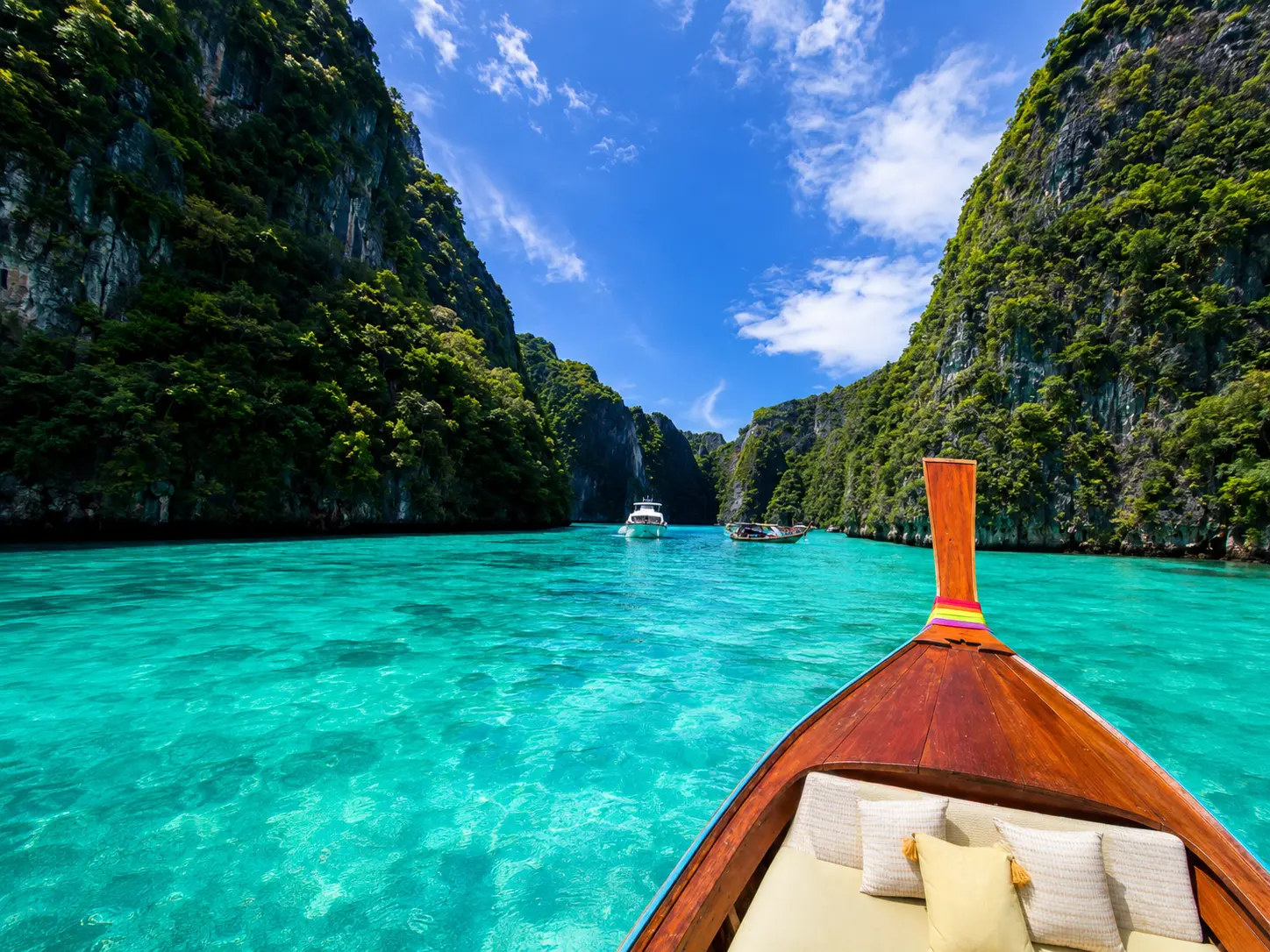 Traditional long-tail boat in the bright turquoise water of Thailand's Phi Phi Islands